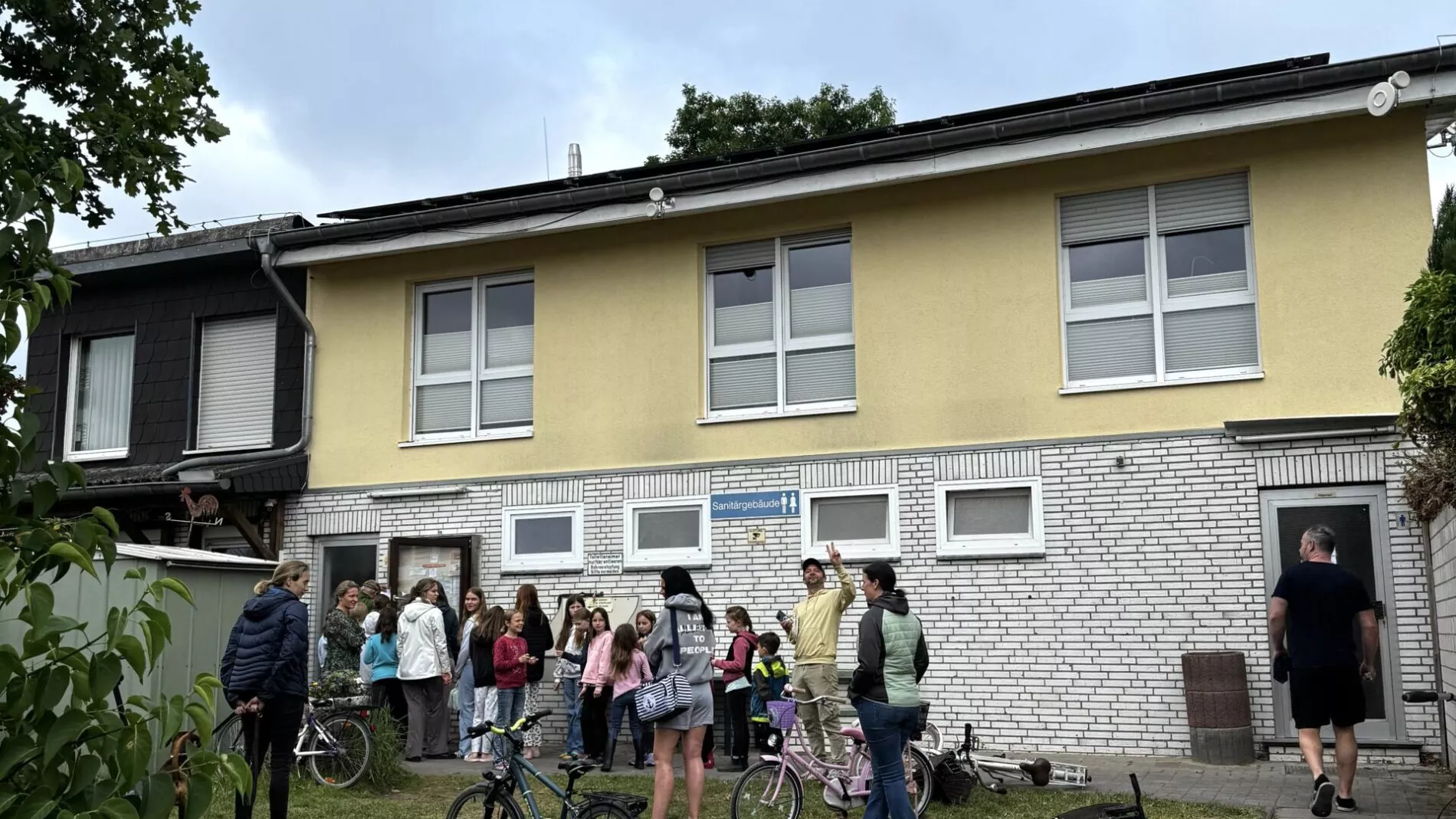 sanitaergebaeude Eine Gruppe Menschen vor einem Gebäude
